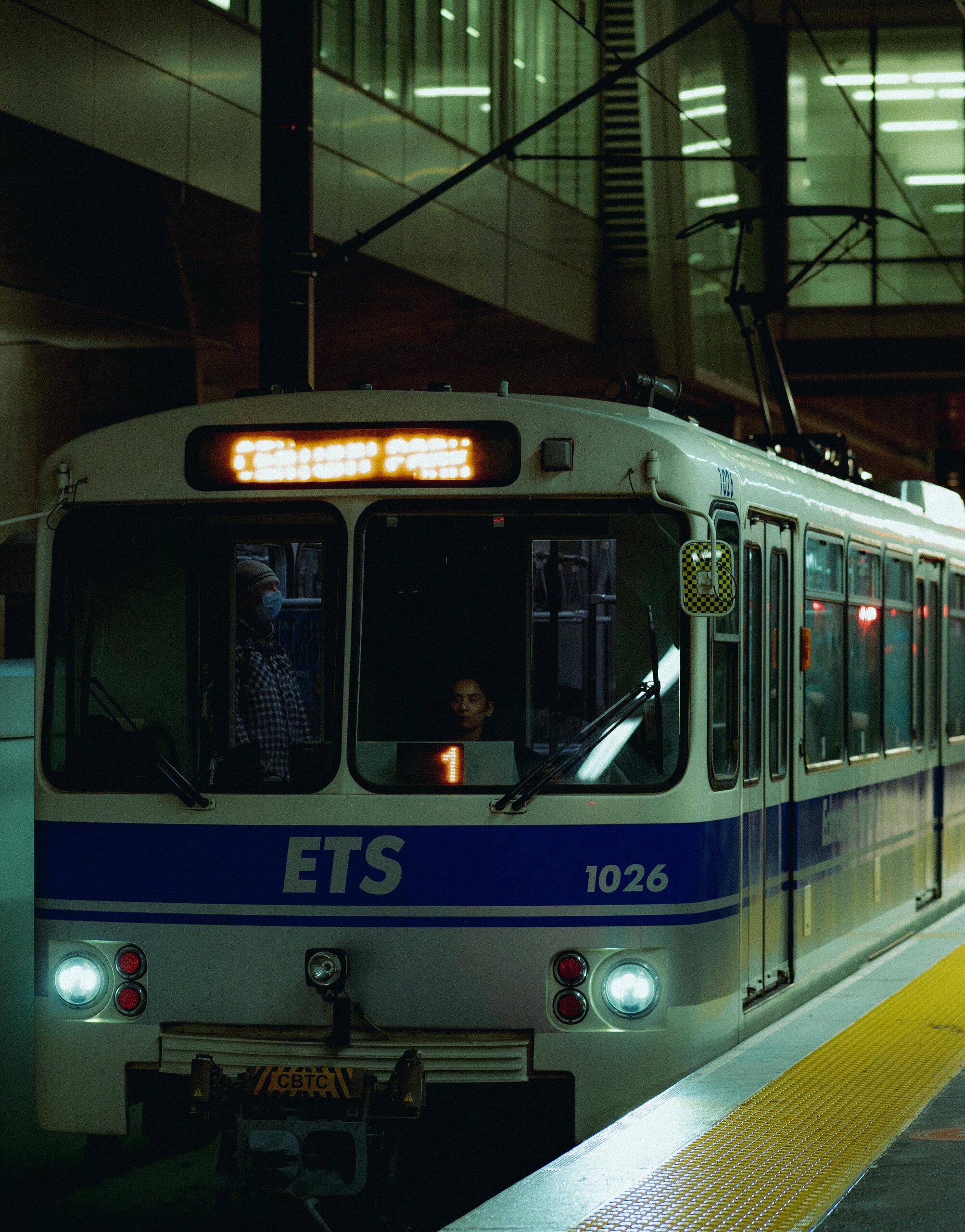 Edmonton LRT train at station with passengers visible at night.